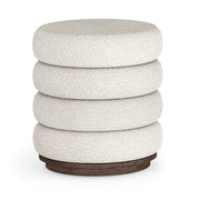 Cylindrical bouclé upholstered footstool with textured fabric and wooden base on a white background