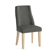 Charcoal grey upholstered chair with wooden legs on a white background