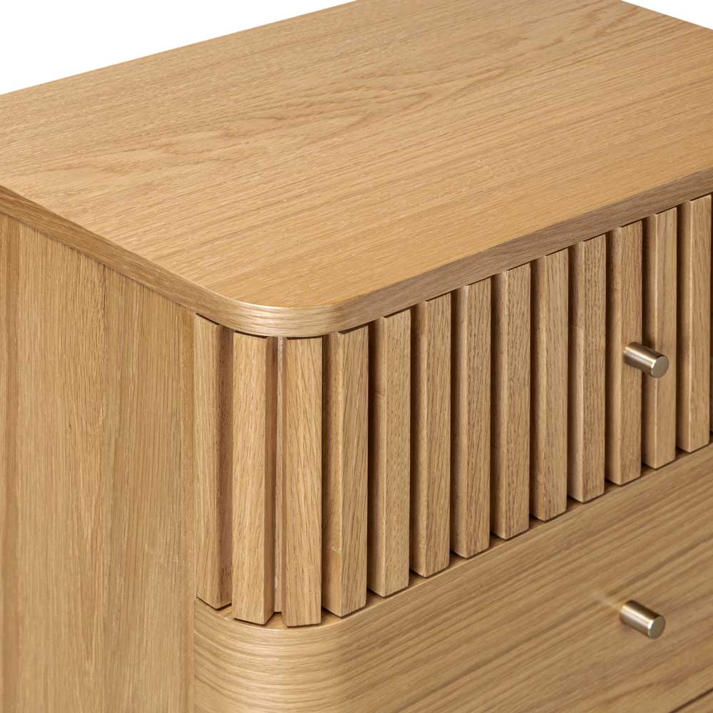 Wooden chest of drawers with a slatted design and gold effect handles on a white background