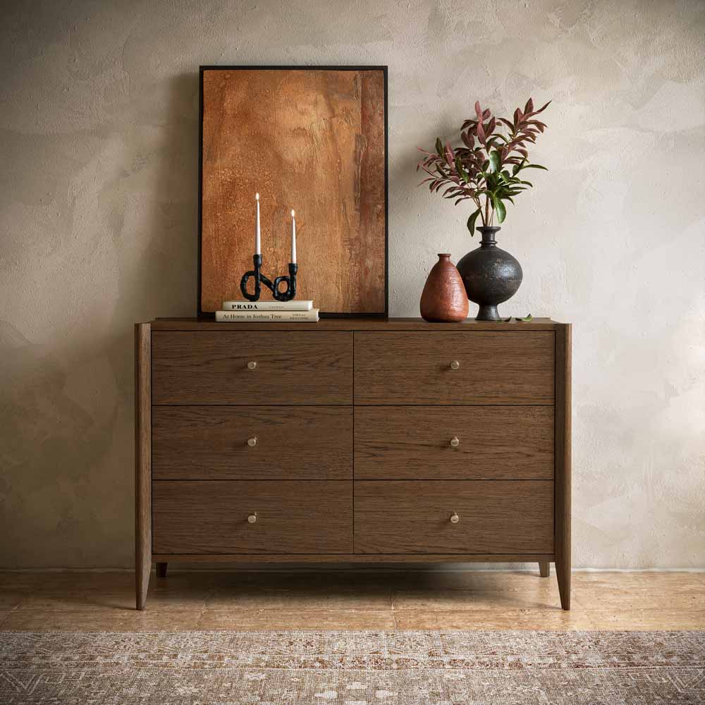 Brown Oak 6 drawer Wooden dresser with decorative items against a beige wall