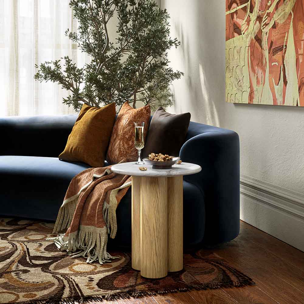 Modern living room with a blue sofa, wooden side table, and decorative elements.