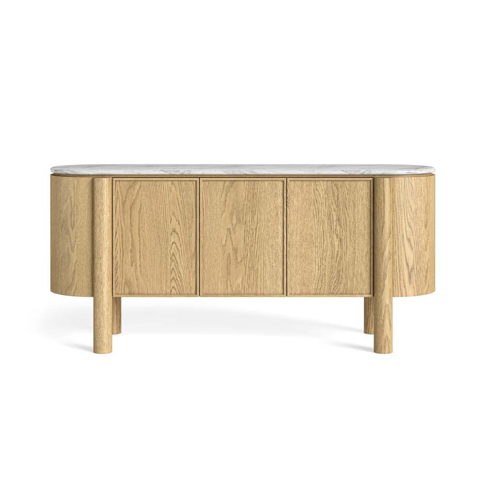 An oval-shaped sideboard cabinet with a light oak wood finish, featuring three front doors, cylindrical legs, and a polished white marble top, shown against a plain white background.