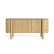 An oval-shaped sideboard cabinet with a light oak wood finish, featuring three front doors, cylindrical legs, and a polished white marble top, shown against a plain white background.