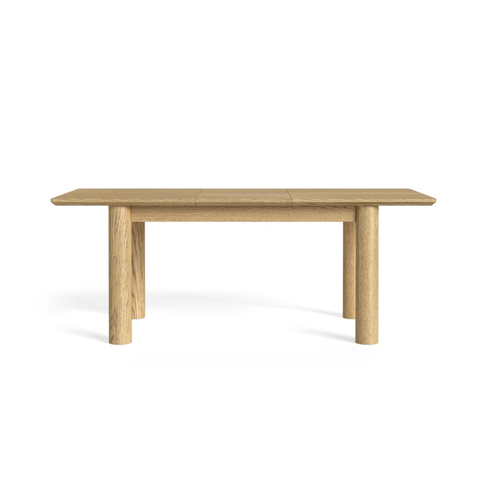 A light oak wood extendable dining table with a rectangular top and four cylindrical legs, shown on a solid white background.