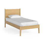 Wooden bed frame with white mattress and pillow on a white background