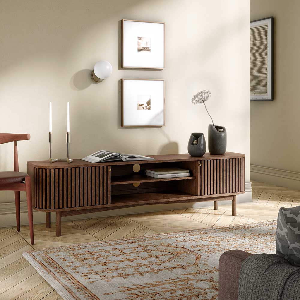 Wooden TV table in a living room setting with decor items.