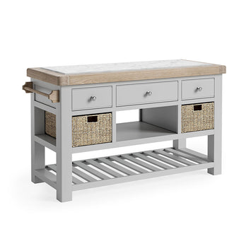 Oak Kitchen Island, oak and marble top. Underneath the storage has been broken into three section. First, 3 grey drawers, next, an open storage space flanked by a storage basket on either side, finally a completely open storage section with grey wooden slats. there is also a towel rail on the left side.