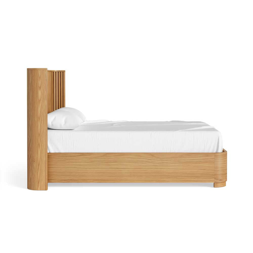 Wooden bed frame with white bedding on a white background