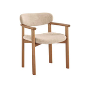 A modern dining chair with a light beige textured fabric seat and backrest, supported by a warm brown wooden frame with integrated armrests, shown against a plain white background.