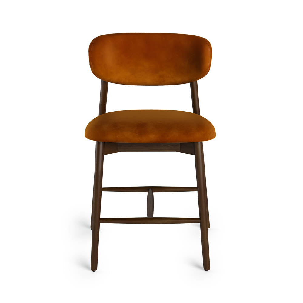 Rustic orange velvet cushioned bar stool on a white background