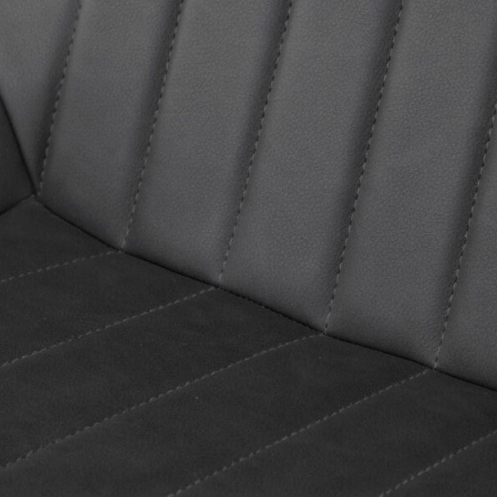 Close-up of a dark gray upholstered seat with vertical channel stitching and a quilted lower section.
