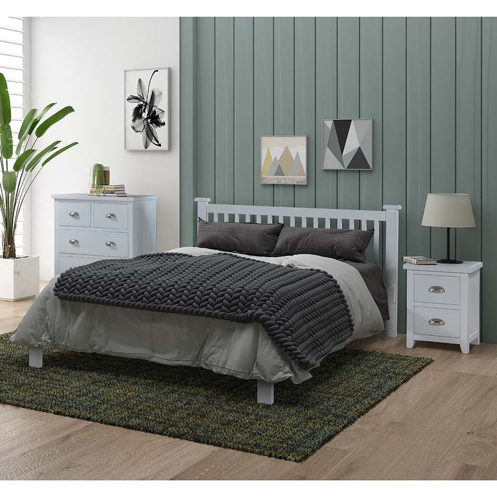 Bedroom with a white bed, gray bedding, and nightstands against a green paneled wall.