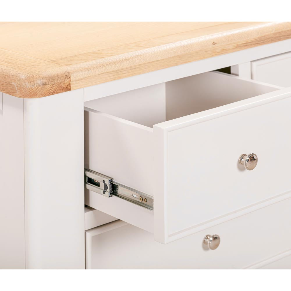 Light grey-beige chest of drawers with an oak top and open drawer.