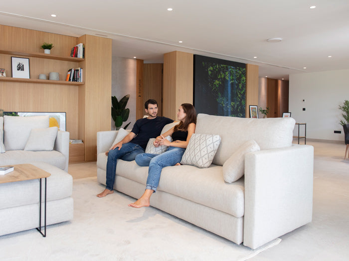 Hector Sofa by Fama with 2 Models sitting down conversing, Side profile