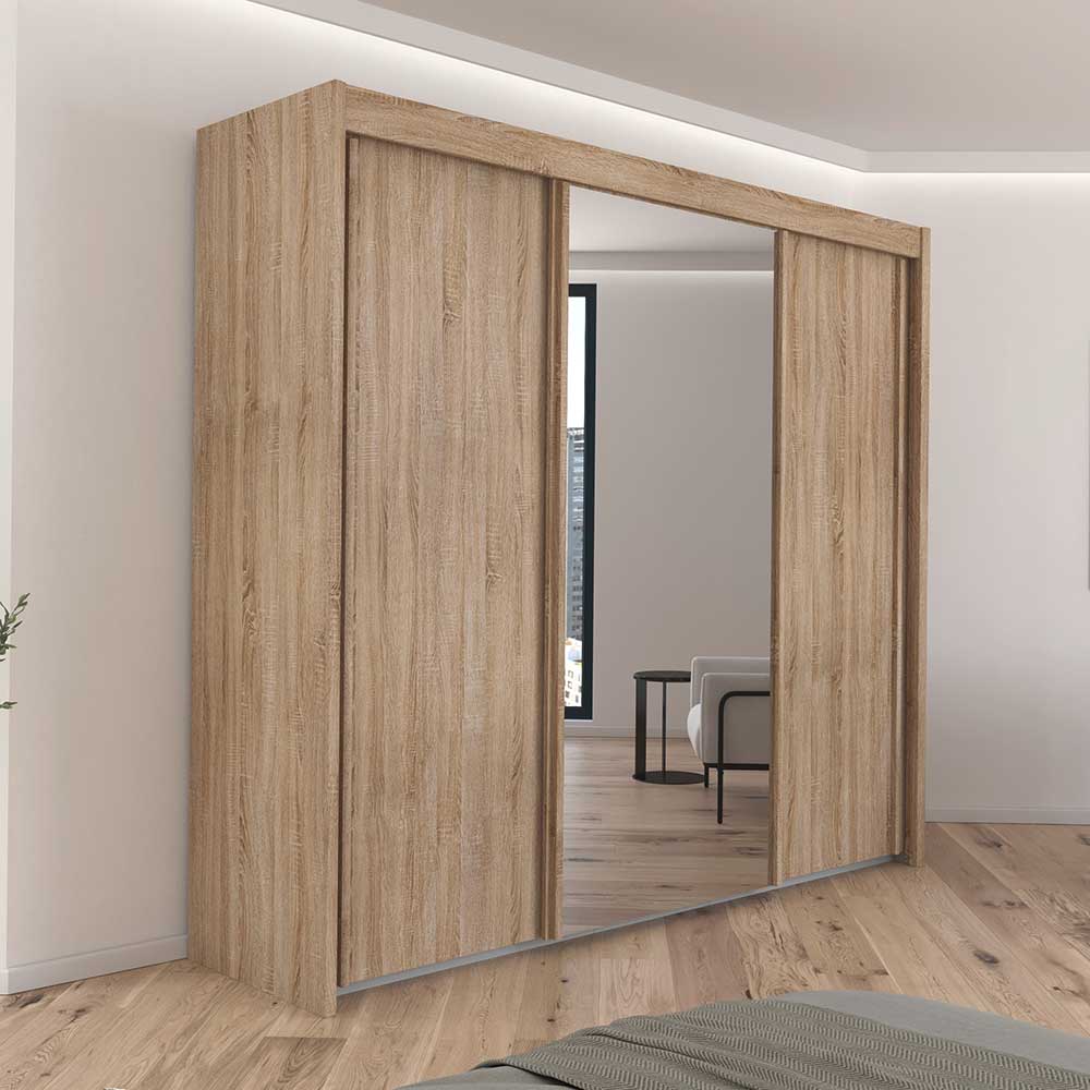 Wooden wardrobe with sliding doors in a room with a mirror reflection.