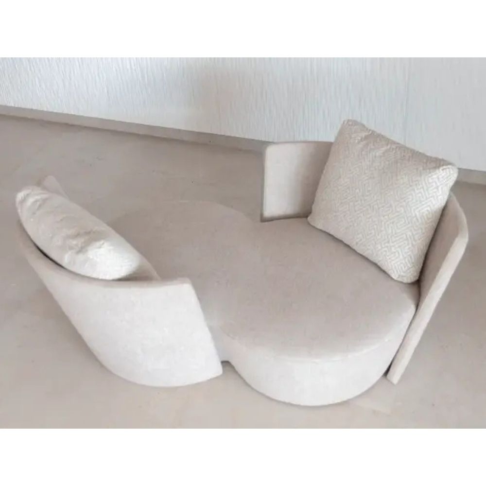 Modern beige infinity sofa with decorative pillows on a neutral background