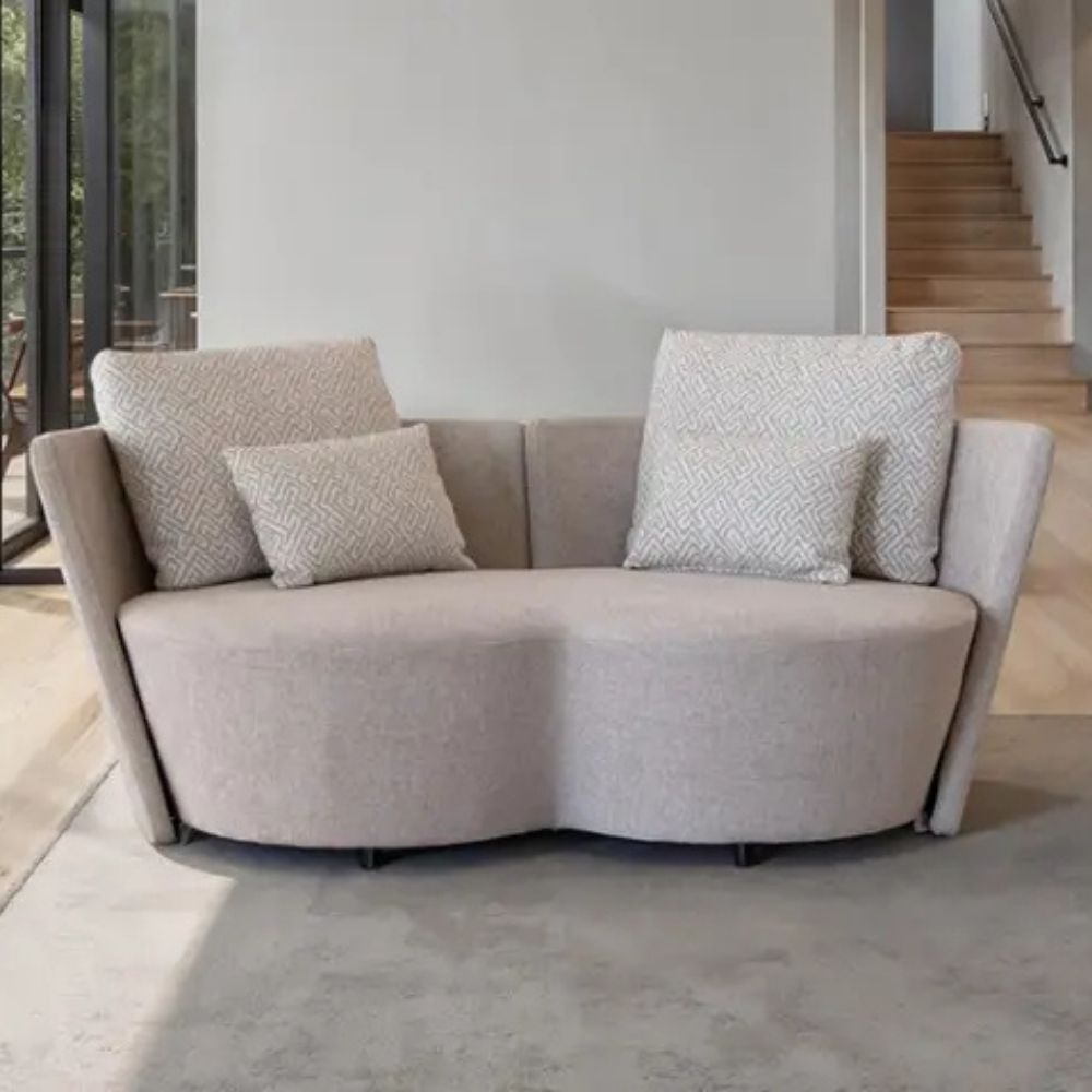 Beige infinity sofa with patterned cushions in a modern living room setting