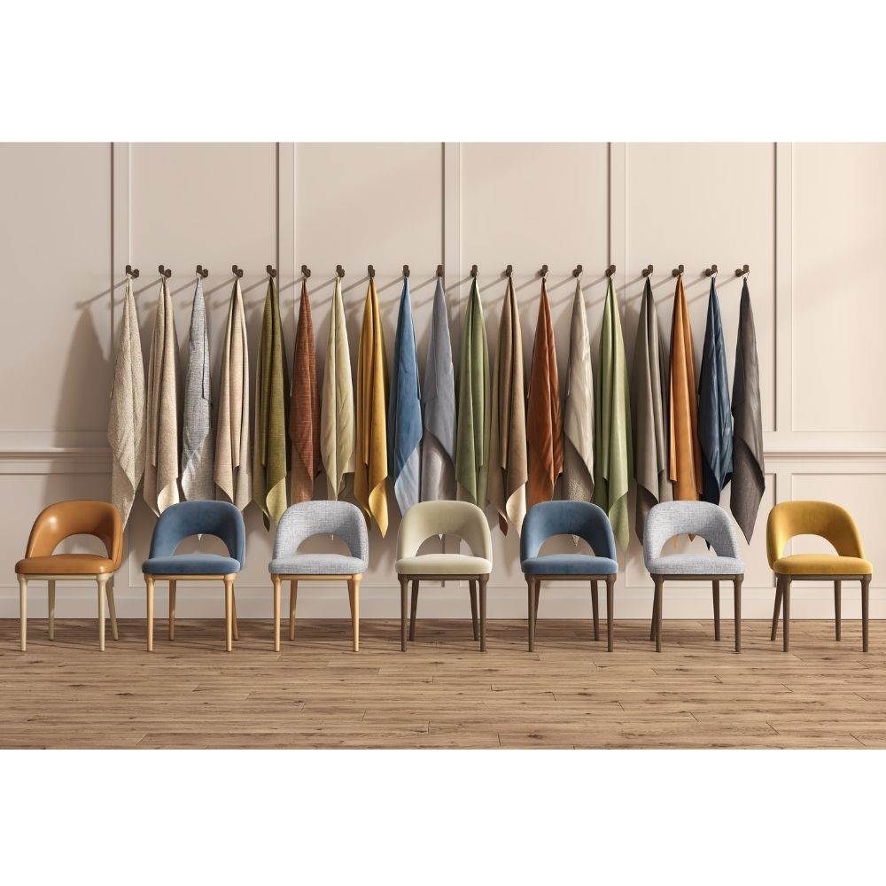 A row of modern accent chairs in assorted colors stands against a beige paneled wall with a hanging rack of folded textiles behind them.