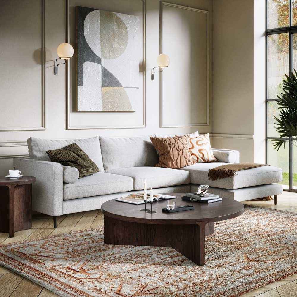 Modern living room with a gray sectional sofa, wooden coffee table, and abstract art on the wall.