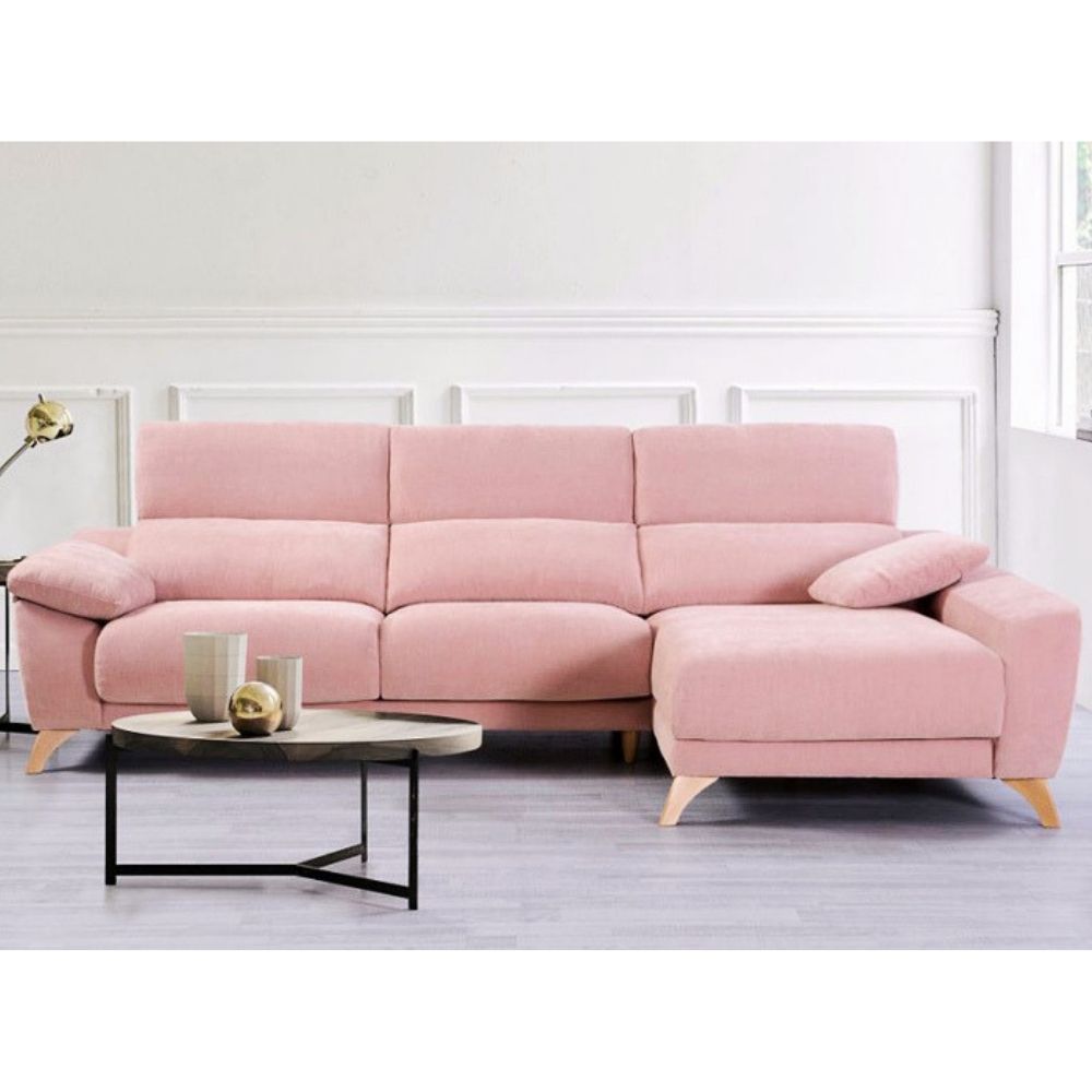 Pink sectional sofa in a room with a white wall and light wood floor.