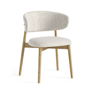 Chair with white bouclé fabric upholstered seat and backrest on a white background