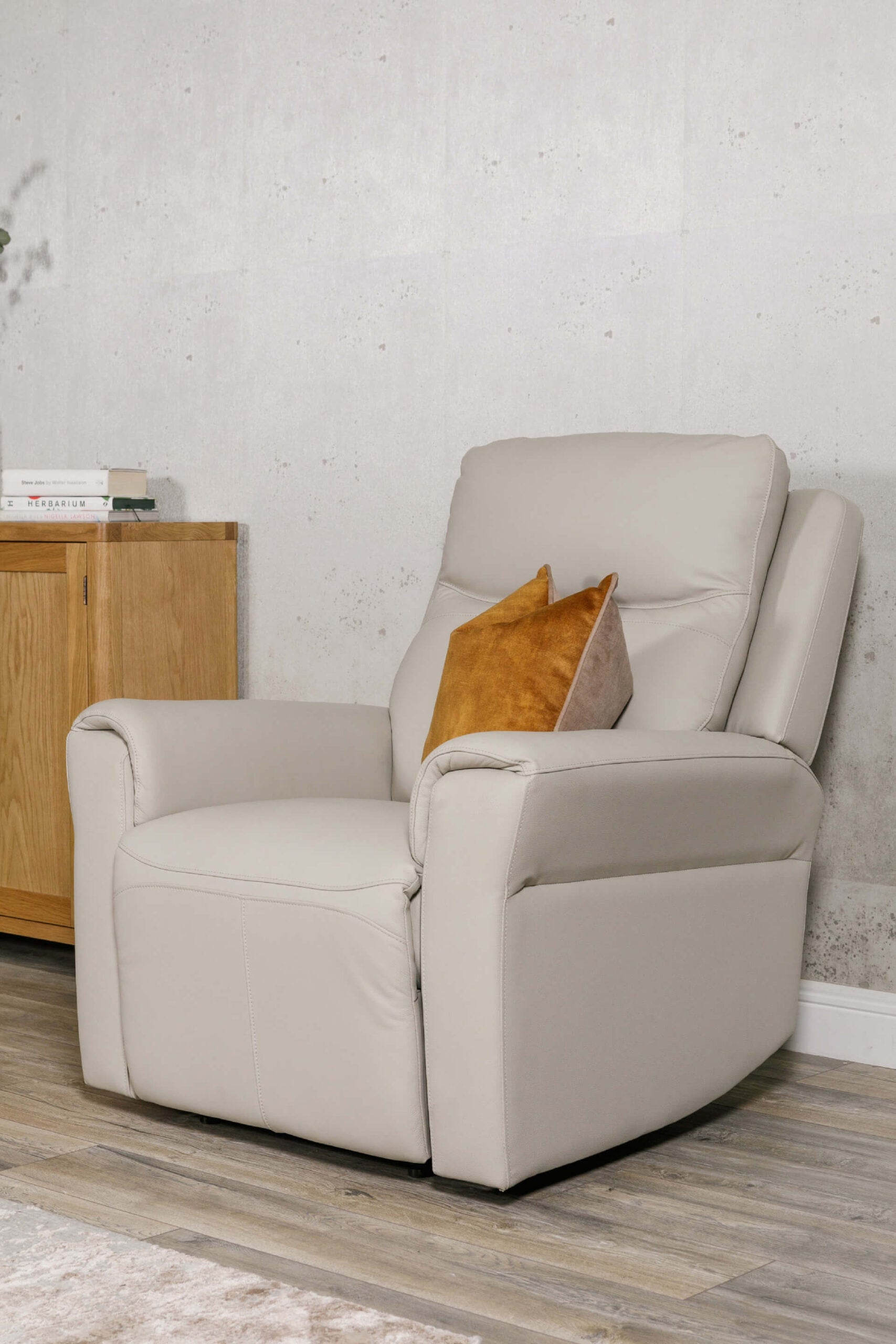 Beige recliner chair with a wooden cabinet and textured wall in the background