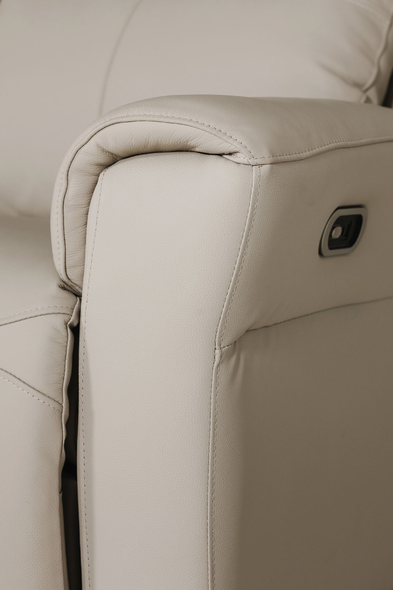 Close-up of a beige leather armchair with stitching detail