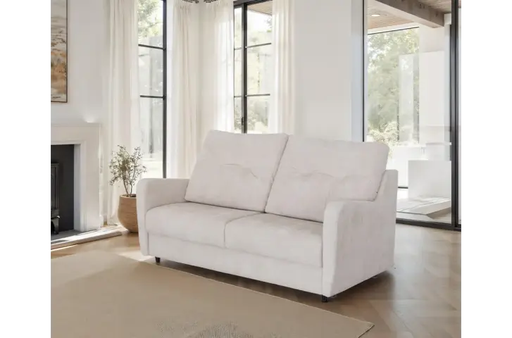 White sofa in a living room with large windows and a fireplace.