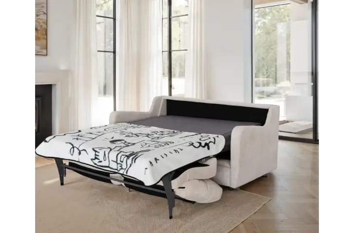 White sofa bed with a black and white patterned blanket in a modern living room.