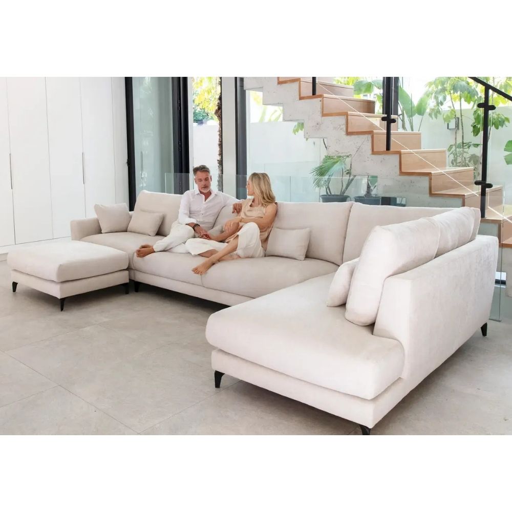 Modern white Fama sectional sofa in a stylish living room with a couple sitting on it.
