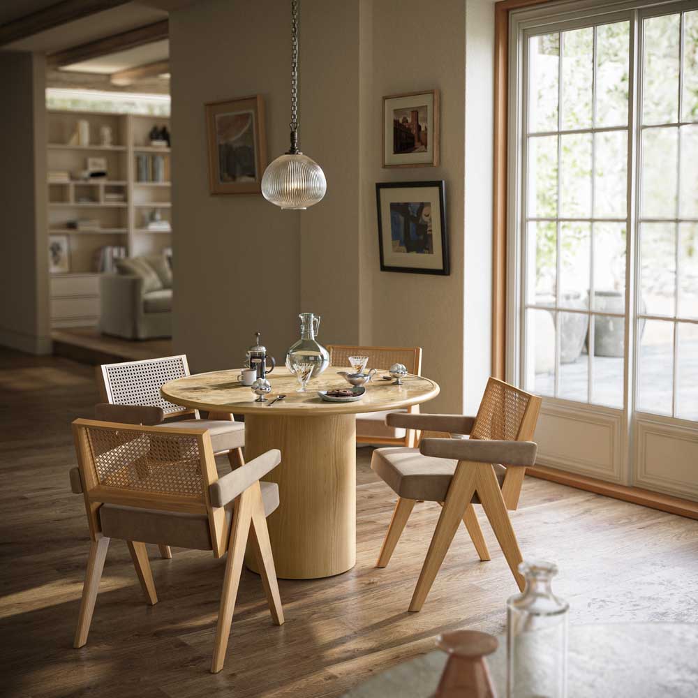 Dining room with a round table and aria dining chairs near a large window.