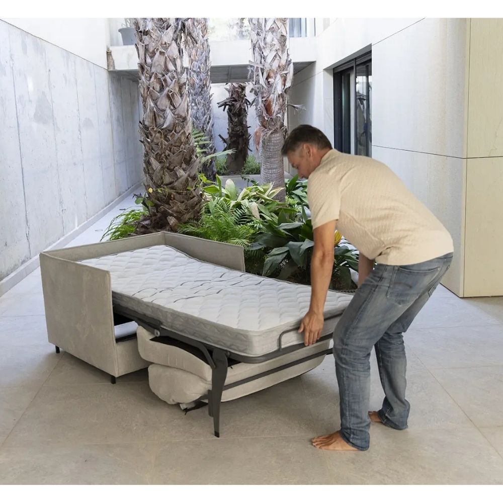Man adjusting a pull-out bed in a modern living room.