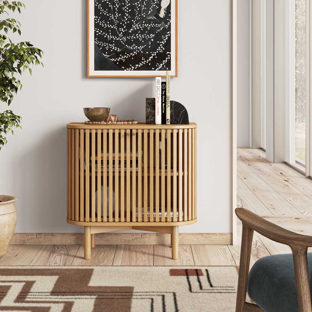 Wooden freestanding cupboard with decorative items in a room with a plant and window.