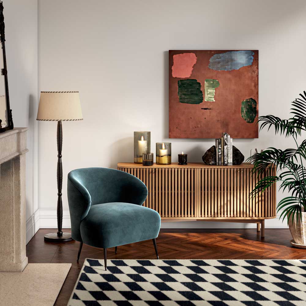 Large sideboard in living room setting with candles and books on top of it