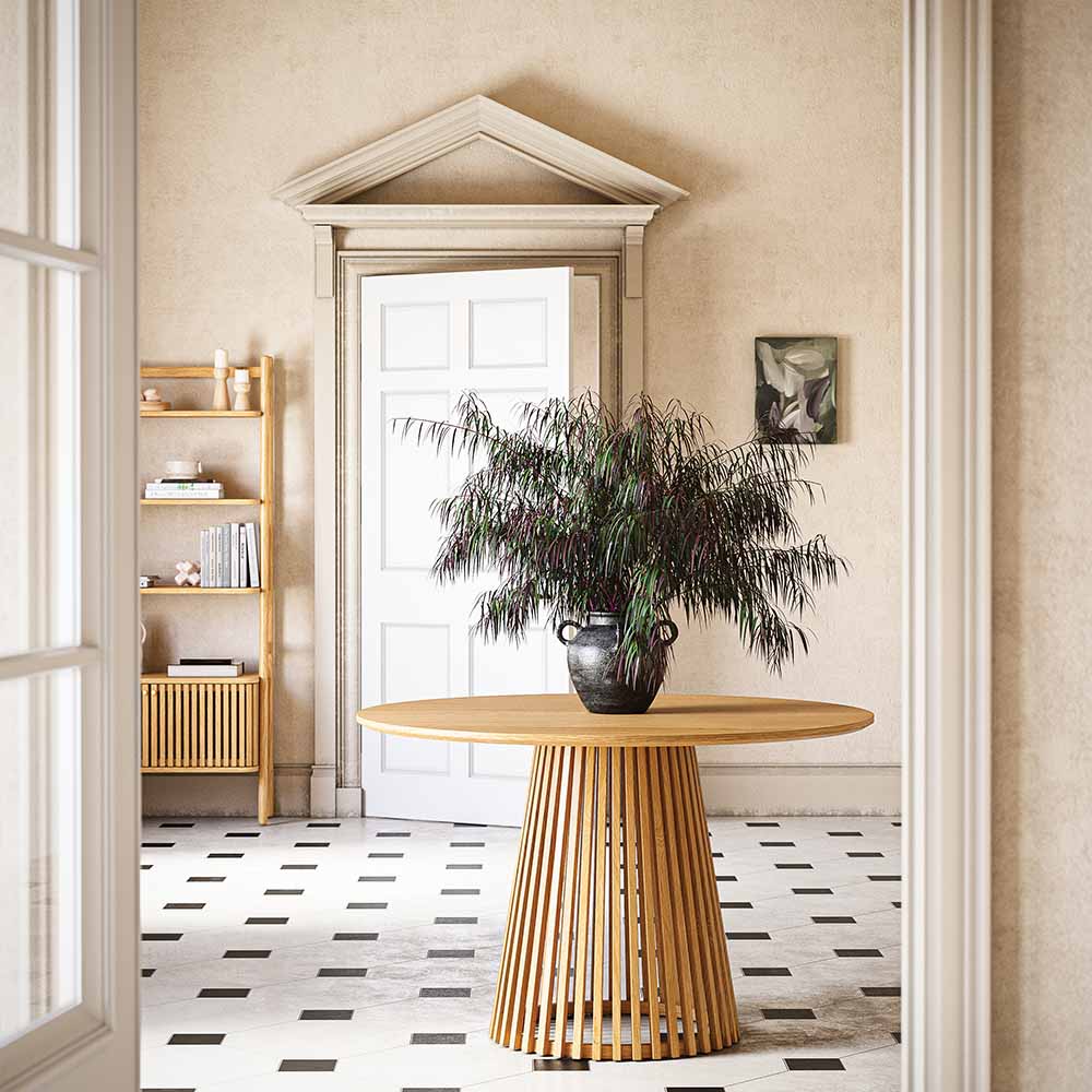 Wooden dining table with a plant in a room with a door and shelves.