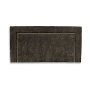 Charcoal upholstered headboard with a studded metal design on a white background