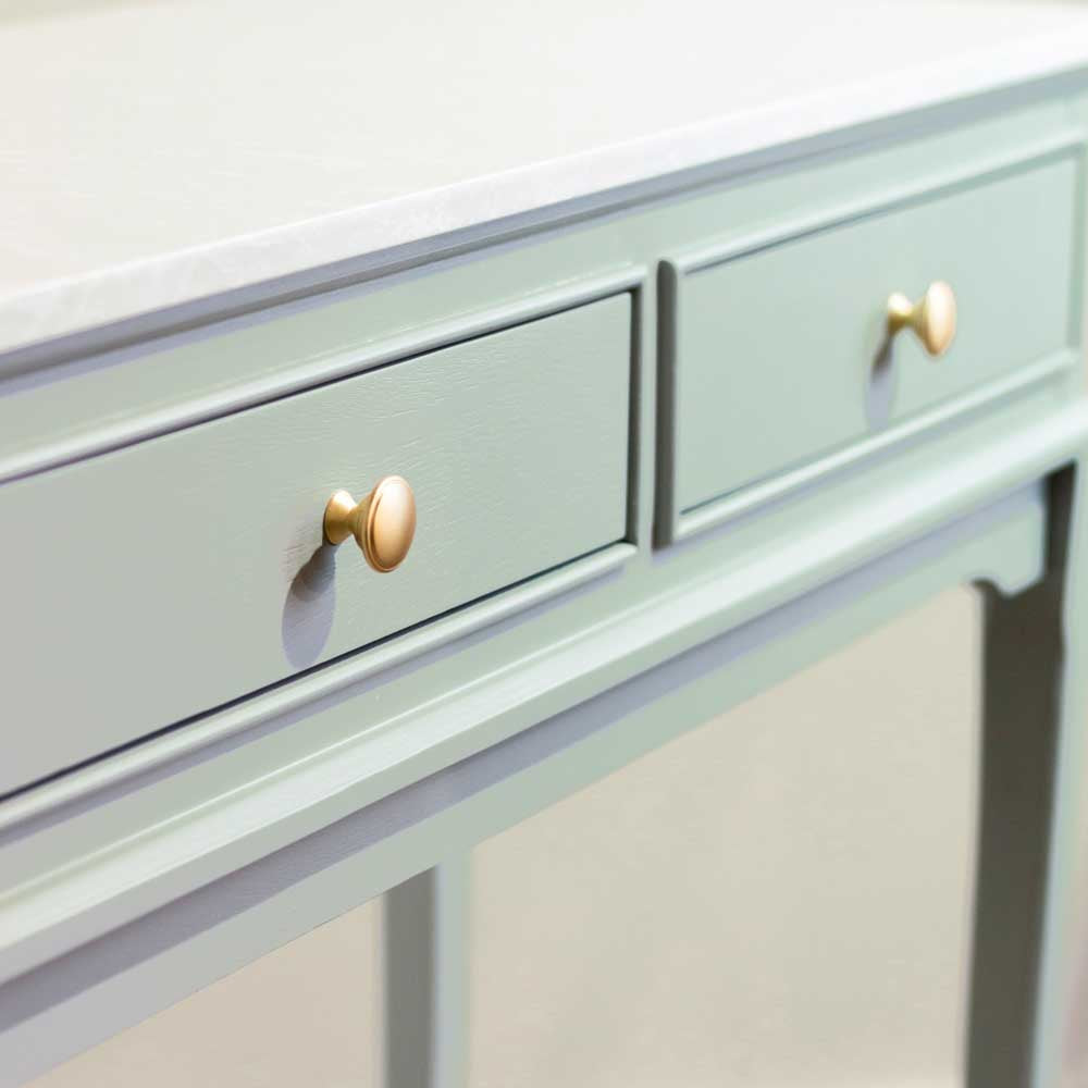 Close up of Sage green console table drawers with brushed brass / gold coloured handles