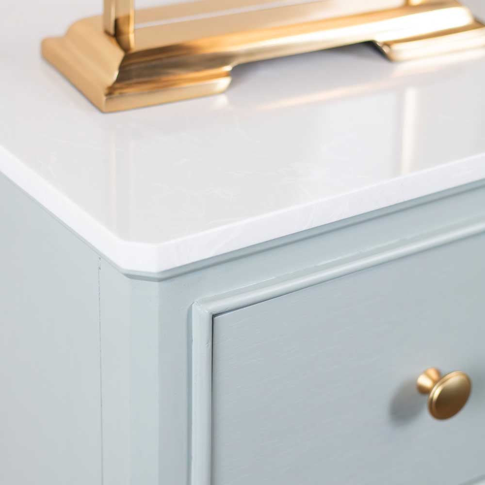Sage green cabinet with white marble countertop and gold fixtures
