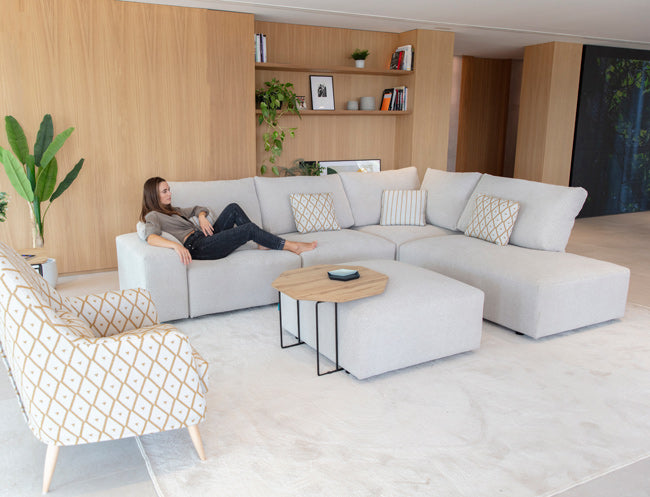 Teseo Corner in smaller size with Chaise end on right. Model Sitting down on left