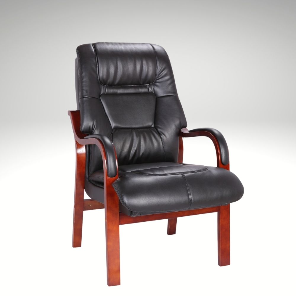 Black leather fireside chair with wooden armrests on a gray background