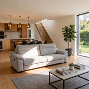 Modern living room with a gray sofa, coffee table, and staircase in the background.