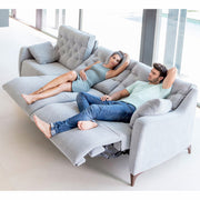 Large Avalon Sofa by Fama with 2 models using motorised recliner in middle seat and right seat.