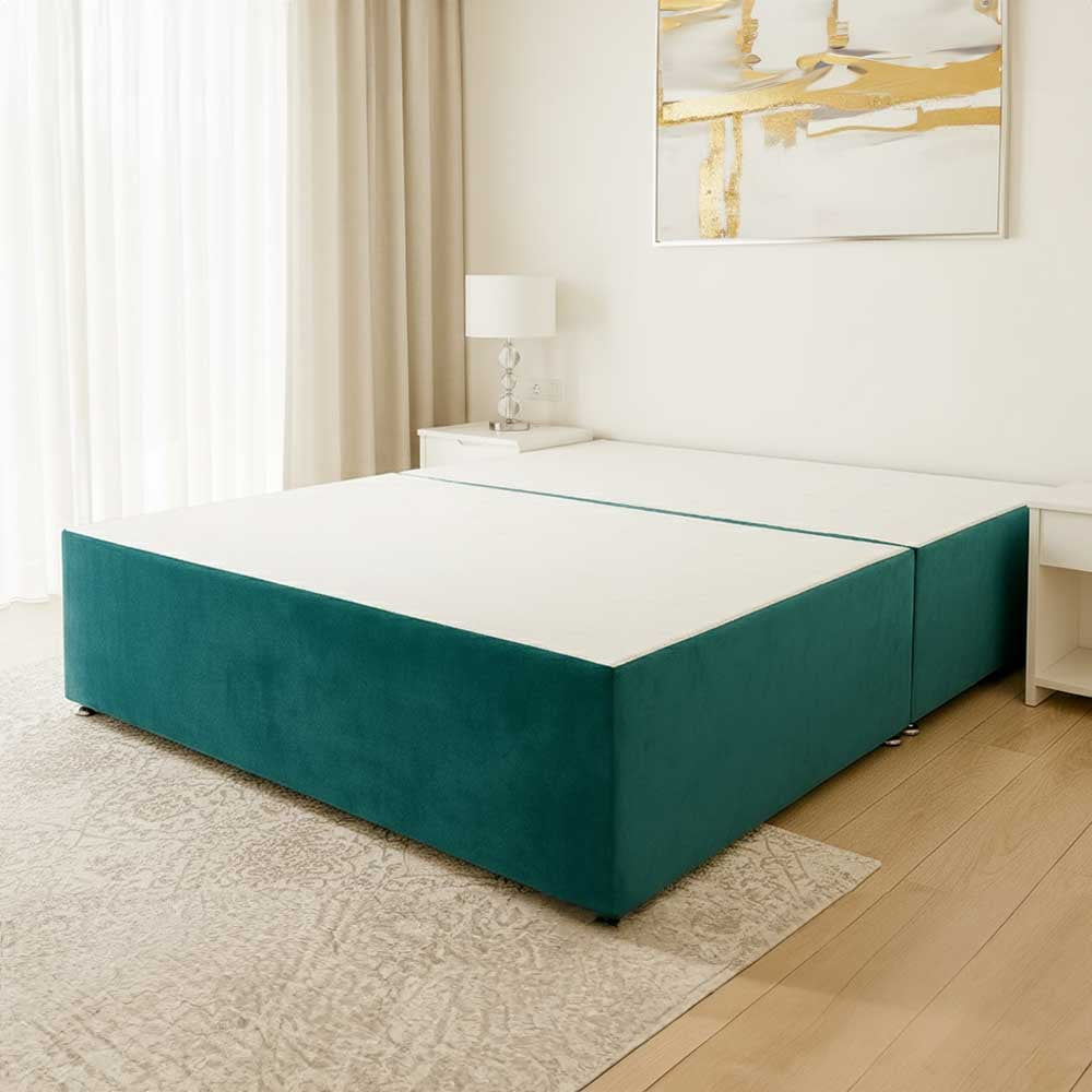 Teal divan bed frame in a bedroom setting with a lamp and abstract painting on the wall.